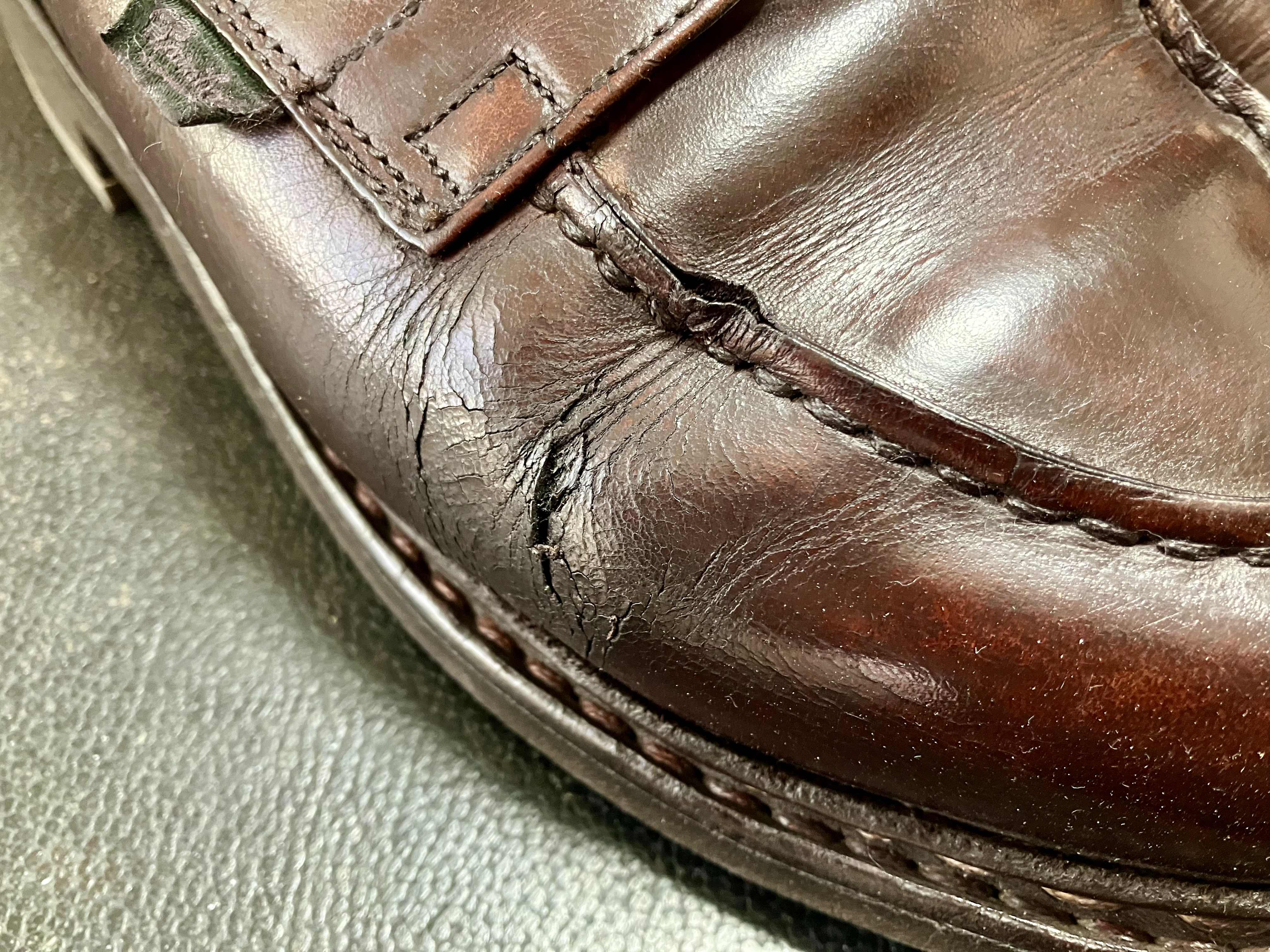 屈折部から深いひび割れが入った革靴